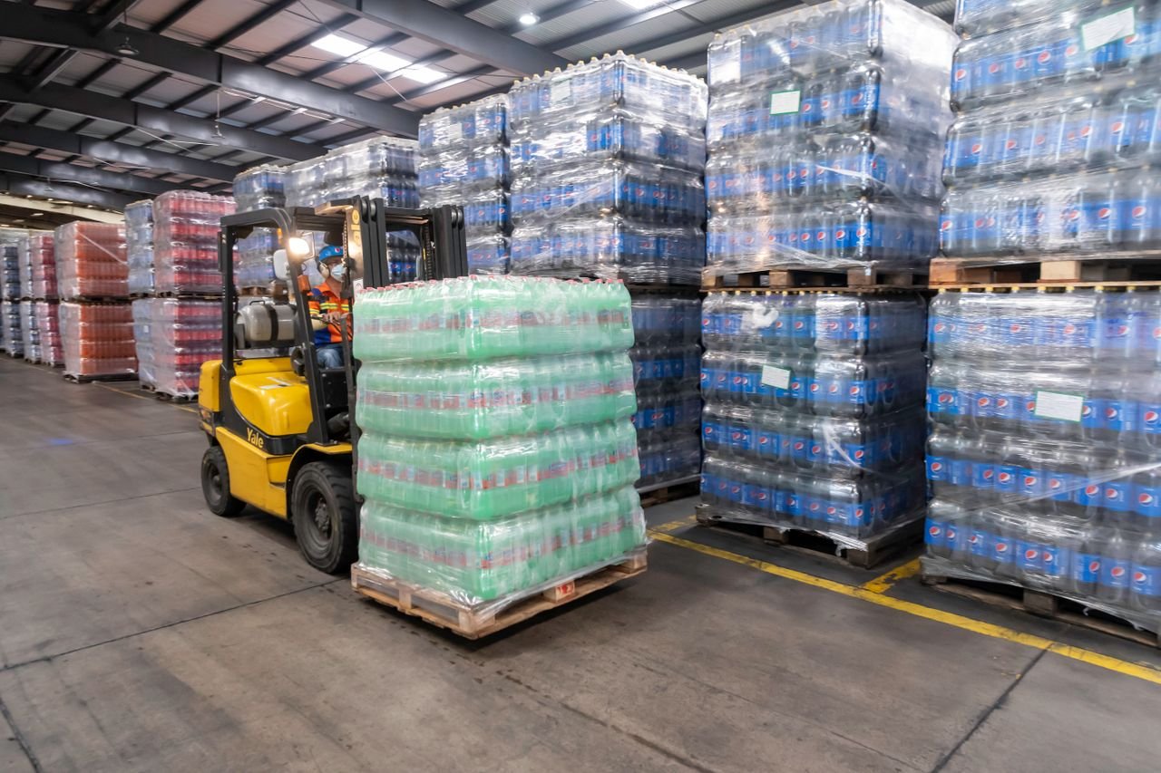 Crafting Captivating Headlines: Your awesome post title goes here A forklift operator moves stacked pallets in a busy warehouse setting.