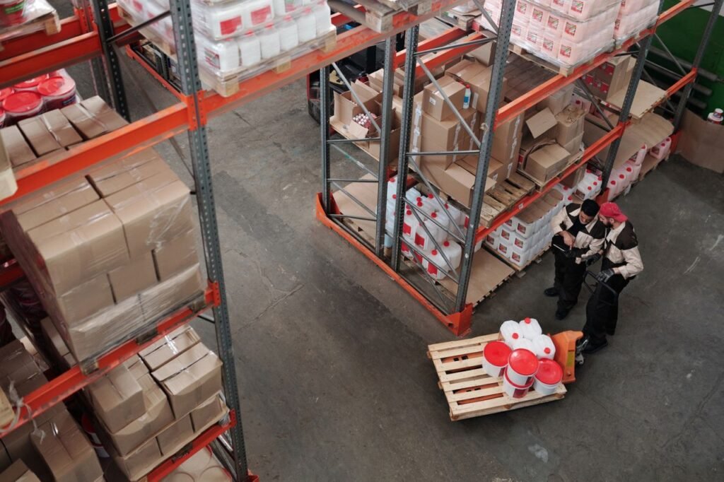 Mastering the First Impression: Your intriguing post title goes here Workers managing inventory on shelves in a warehouse, viewed from above.