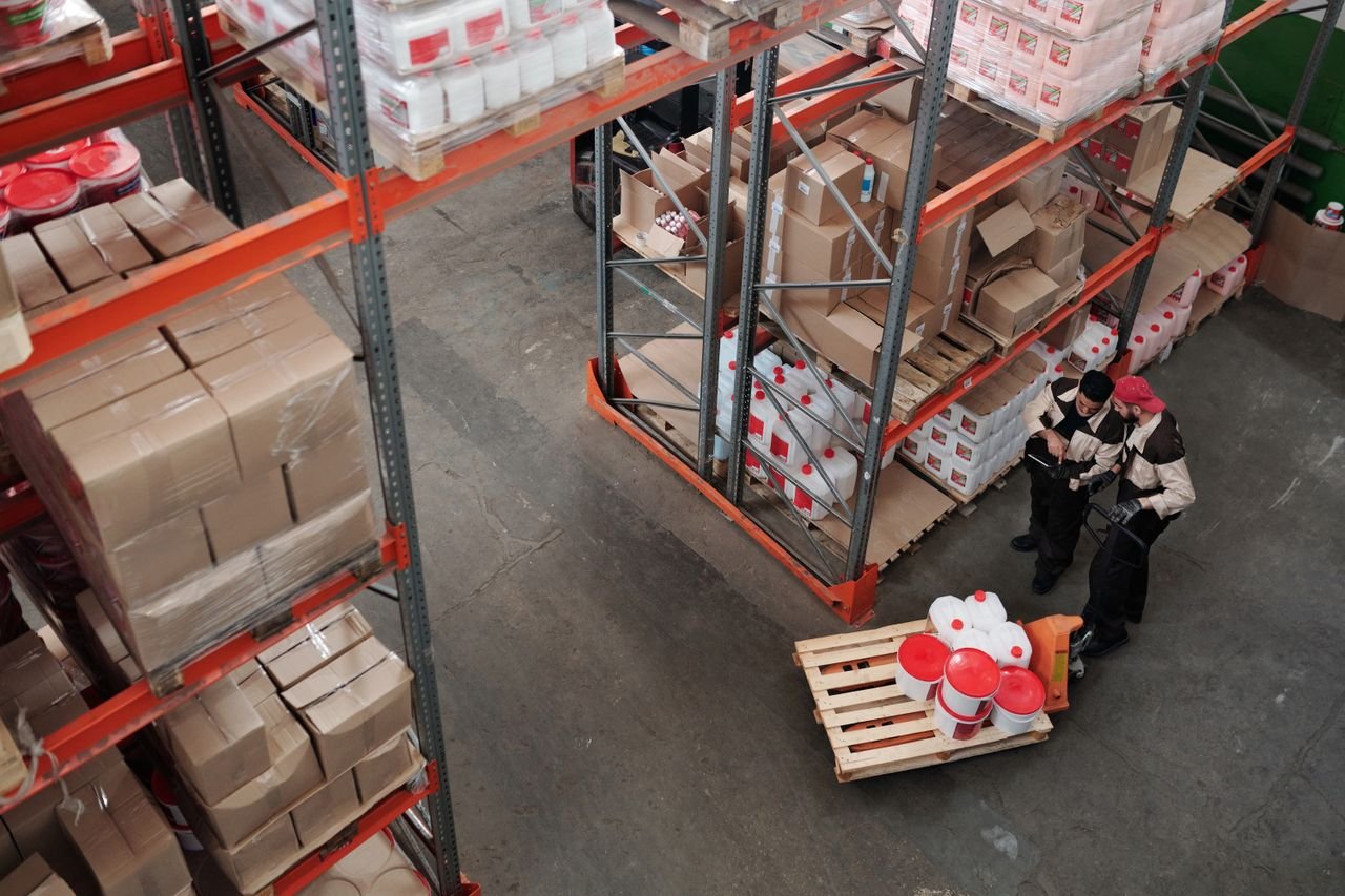 Mastering the First Impression: Your intriguing post title goes here Workers managing inventory on shelves in a warehouse, viewed from above.